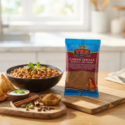GARAM-MASALA-Ciemna-ceramiczna-miska-z-aromatycznym-Chana-Masala-curry-z-ciecierzycą-w-pomidorowo-korzennym-sosie-z-kolendrą-i-imbirem-chrupiące-samosy-świeży-dip-miętowy-i-całe-przyprawy-korzenne-i-miseczka-ze-świeżo-mieloną-mieszanką.png