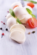 slodki-ser-mozzarella-z-bazylia-i-pomidorami-na-drewnianym-stole.jpg