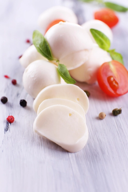 slodki-ser-mozzarella-z-bazylia-i-pomidorami-na-drewnianym-stole.jpg