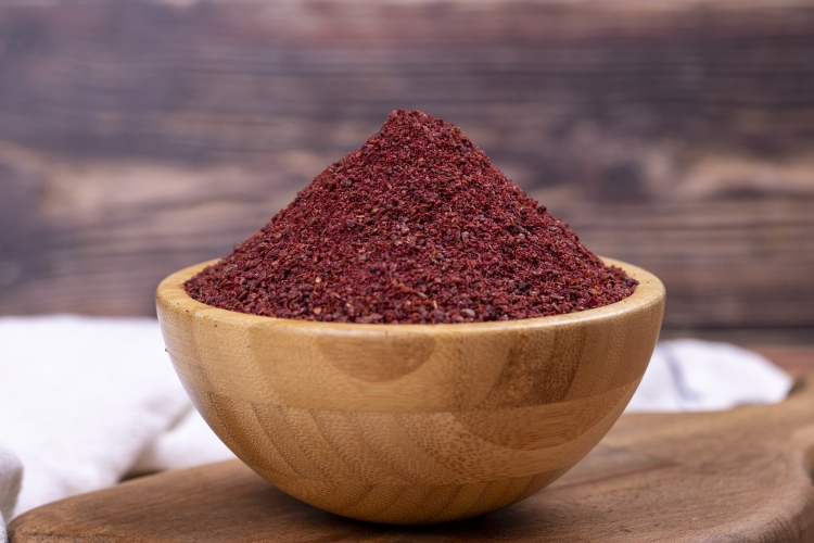 sumac-wooden-background-dried-ground-red-sumac-powder-spices-wooden-bowl-close-up.jpg
