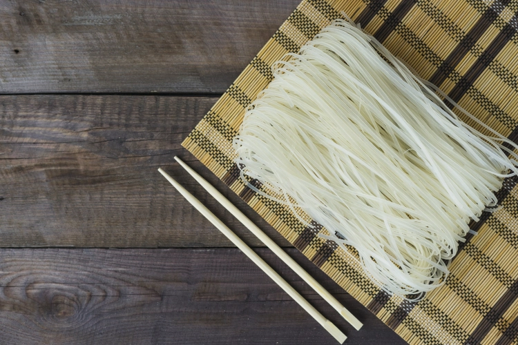raw-rice-noodles-place-mat-chopsticks-weathered-table.jpg