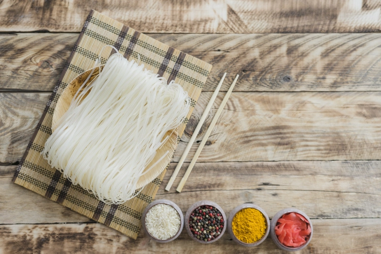 raw-rice-noodles-with-chopsticks-bowls-dry-spices-table.jpg